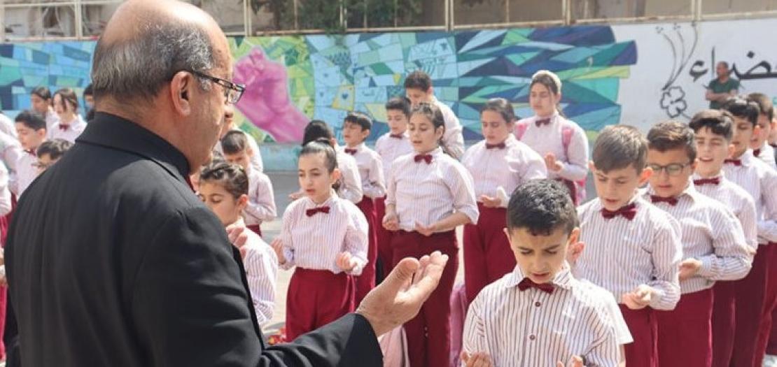 Father Khalil Ja'ar in this undated photo leads prayer at Mary Mother of the Church school's athletic field in Marka, a suburb of Amman, the Jordanian capital.