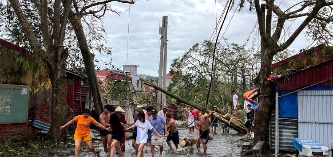 People in Vietnam clearing debris in the aftermath of floods caused by Typhoon Yagi 