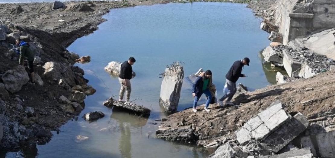 People cross the destroyed Arida border crossing between Syria and Lebanon 