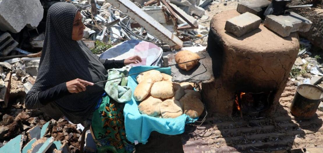 A displaced woman makes bread at a temporary shelter in Gaza City, on 15 April. (