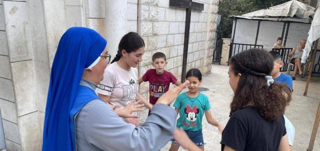 A religious sister works with young people inside the Holy Family parish compound 