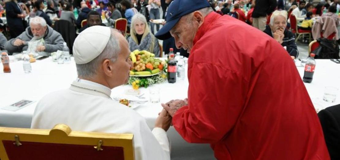 Pope Leo shakes hands with a man attending the lunch in the Paul VI Hall  