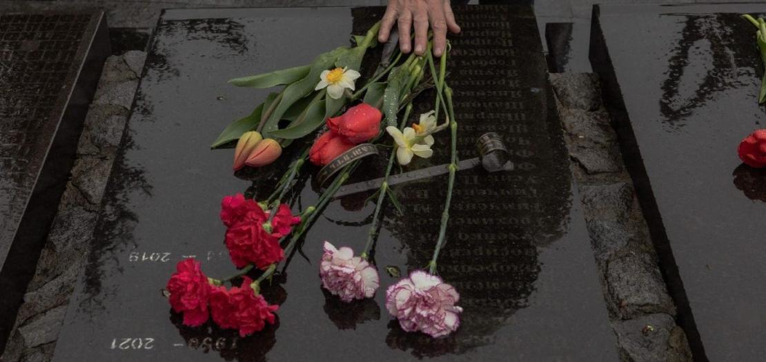 A woman touches flowers at a memorial for victims of Chernobyl in Kyiv