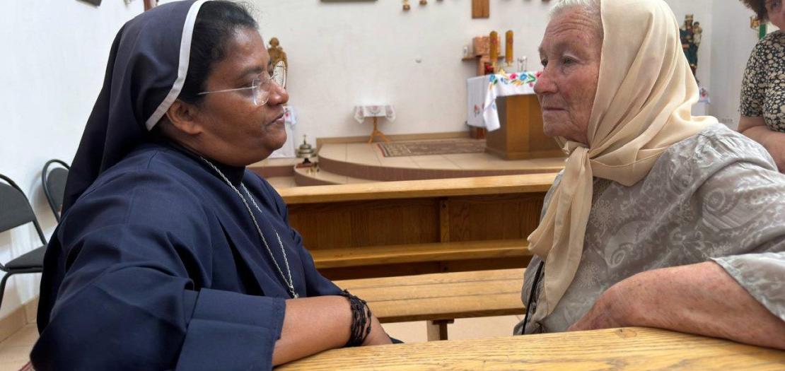 Sister Liji Paiapilli listens to an elderly Ukrainian woman at the parish in Kherson