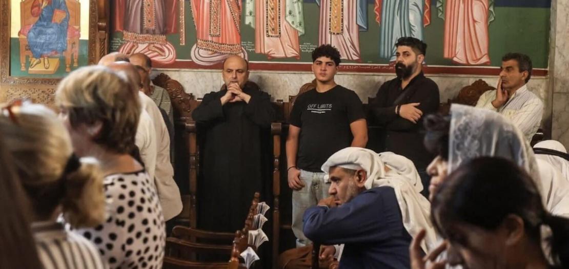 Father Gabriel Romanelli, pastor of Holy Family Parish in Gaza City, with hand clasped, attends the funeral of Mary Hafez Michel Najjar and her mother, Maysa Khader Ibrahim Abu Daoud at St. Porphyrios Greek Orthodox Church in Gaza October 3 