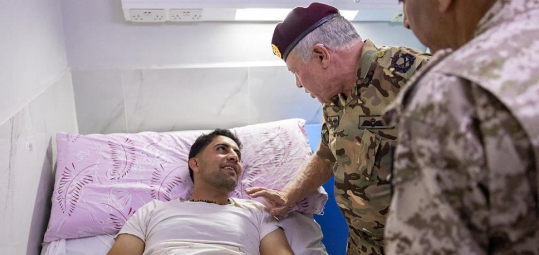King Abdullah II (centre) speaks to one of the people injured at the Prince Ali Military Hospital in Karak, Jordan after gunmen attacked a church during a funeral on October 23, 2026